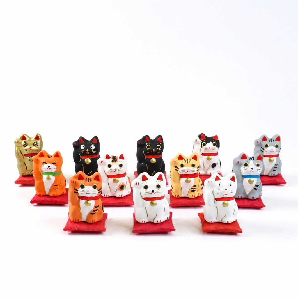 Pequeño Maneki-neko japonés de papel maché con cojín