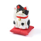 Pequeño Maneki-neko japonés de papel maché con cojín