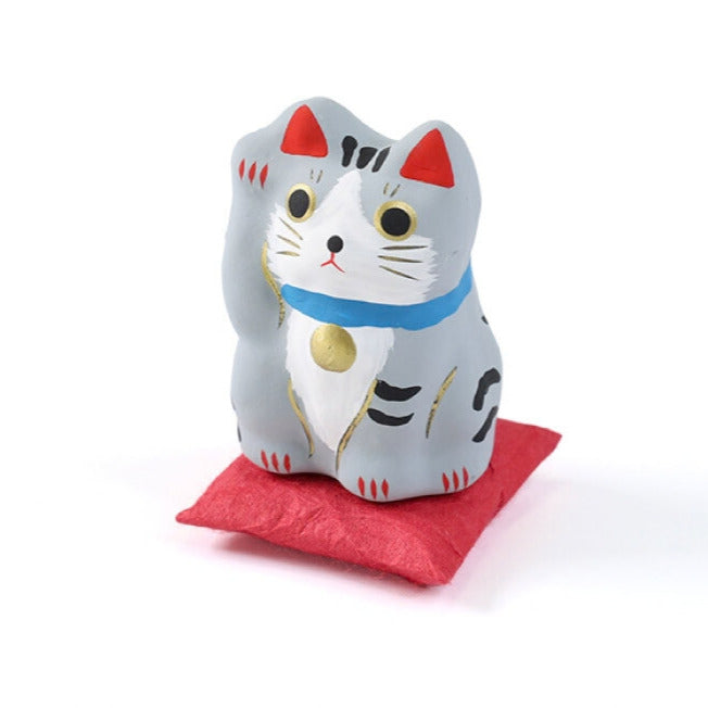 Pequeño Maneki-neko japonés de papel maché con cojín