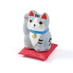 Pequeño Maneki-neko japonés de papel maché con cojín