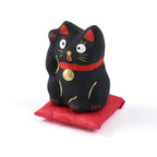 Pequeño Maneki-neko japonés de papel maché con cojín