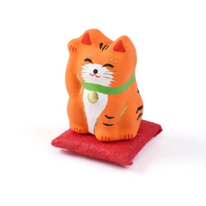 Pequeño Maneki-neko japonés de papel maché con cojín